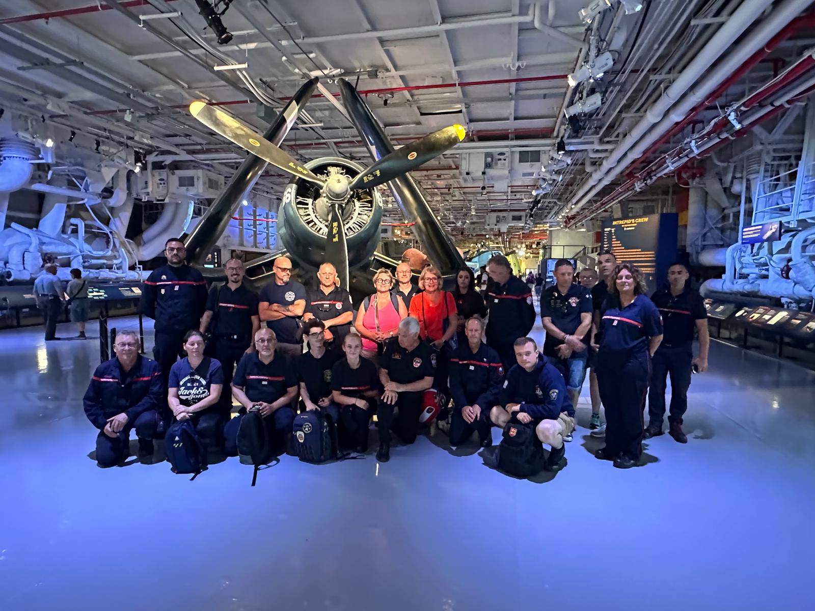 Le groupe de pompiers français au musée du port avion l’Intrepid sea Air Space - En fond un Corsair de la Seconde Guerre Mondiale Le groupe de pompiers français au musée du port avion l’Intrepid sea Air Space - En fond un Corsair de la Seconde Guerre Mondiale